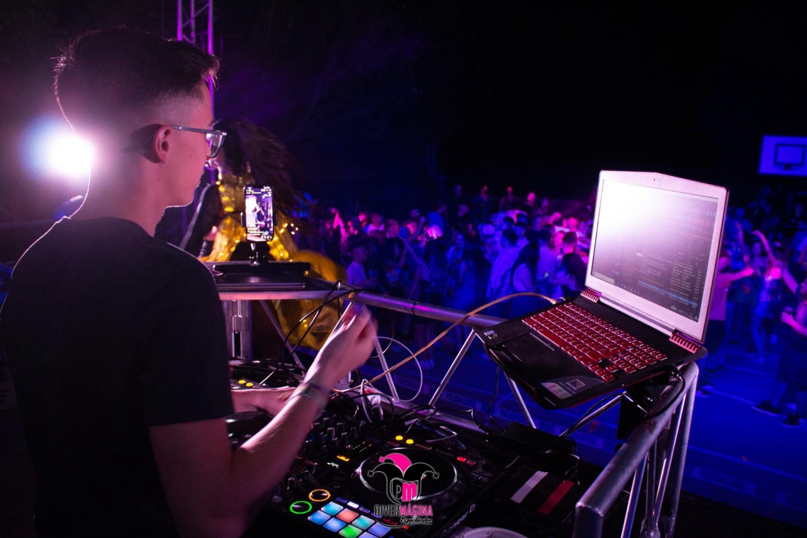 DJ Pyru pinchando de noche ante el público en un evento al aire libre
