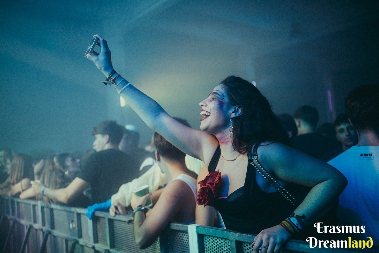 Chica disfrutando y haciéndose una foto entre el público de un evento de DJ Pyru